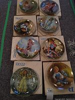 All 8 collector plates displayed on their original RECO boxes, showing front artwork and arrangement