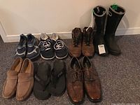 Front view showing six pairs of shoes including dress shoes, runners, sandals, and boots