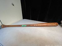 Side view of Easton wooden baseball bat, showing brand and model marking 'PRO 2431' on barrel, placed on white surface.