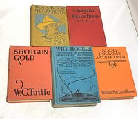 Top view of five vintage western-themed books showing front covers. Titles include Boy's Book of Cowboys (1910), The Bandit of Hells Bend (1925), Will Rogers (1935), Bucky Follows a Cold Trail (1937), and Shotgun Gold (1940). Colors: yellow, red, blue, orange.