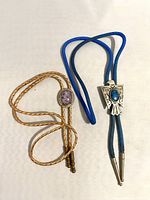 Pair of bolo ties on white background showing both bolo cords and decorative stone areas