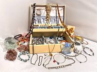Wide view of vintage and costume jewelry in Lady Buxton jewelry box with multiple bracelets, necklaces, and rings laid out around it.