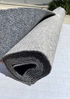 Rolled gray indoor outdoor carpet showing texture and rolled dimension width