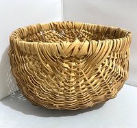 View of vintage Cherokee woven basket with natural multicolor weaving, showing side and top view of the basket structure and weaving pattern.