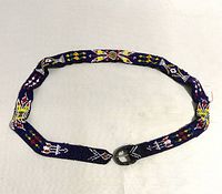 Photo showing the full length of the beaded belt laid flat in a circle, highlighting the intricate bead patterns and metal buckle.