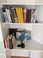 Full view of shelf with assorted books and National Geographic magazines including geography, history, and literature topics