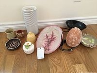 Full view of all assorted porcelain and ceramic decor items plus the pink stone crystal lamp with stand on wooden floor