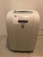 Front view of white Kenmore dehumidifier showing overall unit shape and power cord.