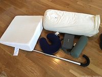 Lot contents showing all pillows and walking cane on wooden floor