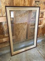 Front view of wood picture frame with linen inset and intact glass, showing wear and no backing.