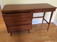 Front view of Vilas mid-century desk showing 4 drawers, wood finish, and tapered legs with brass caps