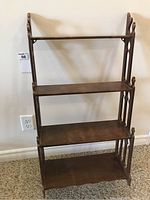 Front view of the vintage wooden wall shelf showing all three tiers and decorative side panels.