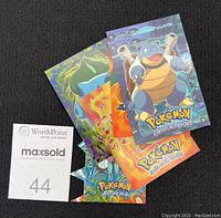 Photo showing front of 6 Pokemon cards stacked with visible artwork of Blastoise, Charmander, and others.