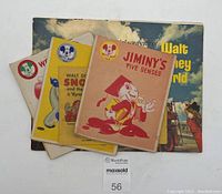 Five vintage Mickey Mouse Club coloring books and a 1971 Walt Disney World pictorial souvenir book stacked with cover visible.