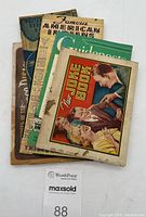 Five vintage booklets and brochures stacked, identifying front images and condition.