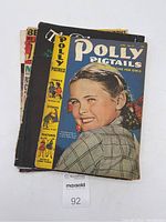 Stack of vintage magazines including the June 1947 Polly Pigtails Magazine for Girls visible on top.