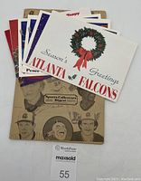 Collection of Sports Collectors Digest magazine and several sports-themed cards including Atlanta Falcons holiday greeting card