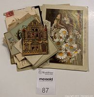 Lot of vintage ephemera, including floral and architectural cards, envelopes with stamps, and handwritten notes.