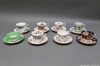 Eight assorted bone china teacup and saucer sets displayed in two rows