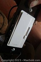 Close-up photo showing a white Legrand dimmer switch with a sliding control installed on a mounting plate, held in hand.