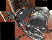 Full side view showing padded seat and armrests, metallic frame, and front wheels.