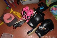 Photo showing pink athletic shoes, Heely's shoes, grey and pink cap, and boxing mitts.