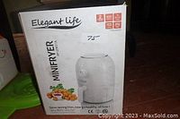 Photo of the Elegant Life Mini Fryer box showing front view with product name, features and 2-year warranty label.