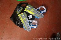 Two Hyper Nerf paint ball blasters placed on black pouch on wooden floor.