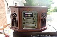 Front view of the Memorex vintage style record player showing wooden mahogany finish and control panel with buttons and radio tuner.