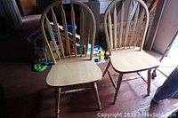 Front view of two wooden kitchen chairs with slatted backs and contoured seats