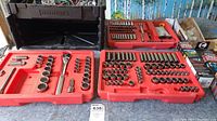 Three red trays showing various sizes of sockets, ratchets, and extensions arranged neatly inside.