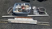 Full overview of all items in lot showing gray plastic bin with assorted fittings and tools, white PVC pipes, and various hoses.