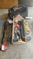 Overall lot showing wood tool boxes with assorted hand tools, measuring tapes, vises, and black fabric tool bag