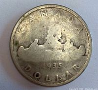 Reverse of 1935 Canadian silver dollar showing the voyageur canoe design and date.