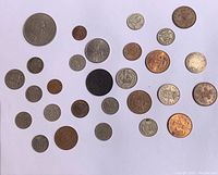 Top view of 40 assorted British shilling and other denomination coins arranged on a white background.