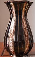 Front view of the brown ceramic vase showing its tall, rounded shape with vertical marbled beige accents and flared scalloped rim.