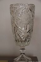 Front view of the crystal vase showing the detailed rose motif etched into the glass and surrounding geometric cut patterns.