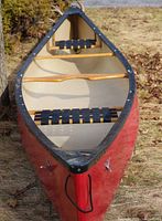 Interior view showing two black webbed seats and wooden thwart yoke at bow