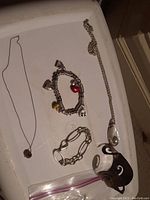 Overview of bracelets, necklaces, and pendant pieces displayed on a white surface.