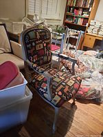 Angle showing the whole chair with visible upholstered seat and back featuring animal and nature patterns