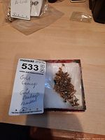 Box containing assorted gold earrings and pendants