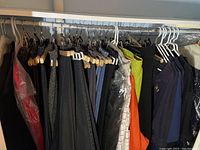 Wide view of women's jeans and jackets hung on rack showing variety of items and colors