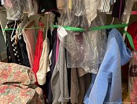 Wide view of hanging women's clothing including jeans and sweaters in various neutral and pastel tones
