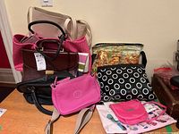 Wide view of lot with various purses, tote bags, and pouches stacked
