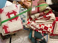 Pile of folded assorted quilts strapped with green band