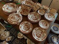 Overview of Spode Indian Tree plates, cups and bowls arranged on table