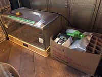 Humex Propatray greenhouse next to a cardboard box of gardening accessories, showing overall lot contents.