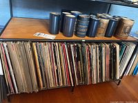Shelf with a row of more than 50 Laserdisc movies in cardboard sleeves