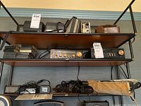Overview of shelves showing cassette recorder, two radios, cables and blank tapes