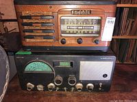 View of two vintage radios stacked: DeForest wooden cabinet radio on top, Hallicrafters S40A metal radio below showing front panels and controls.